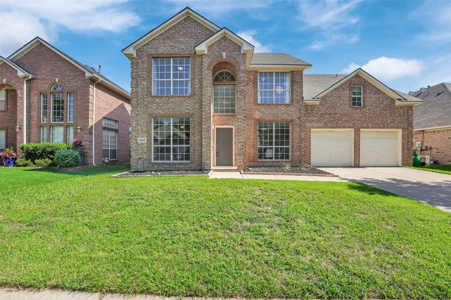Traditional home with concrete driveway, brick siding, and a front yard | Image 34