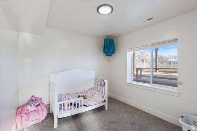 Bedroom with a nursery area, visible vents, baseboards, and carpet | Image 36