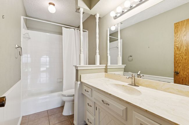 Bathroom featuring vanity, a textured ceiling, shower / bath combination with curtain, and tile patterned flooring | Image 27