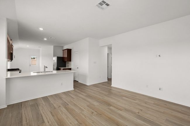 Unfurnished living room featuring a sink, light wood-style flooring, recessed lighting, and baseboards | Image 6