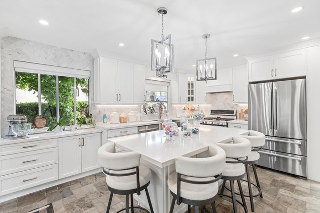 Kitchen with stainless steel appliances, plenty of natural light, light countertops, a kitchen bar, and recessed lighting | Image 14