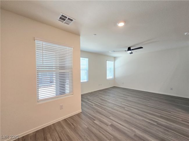 Empty room featuring wood finished floors, baseboards, and ceiling fan | Image 6