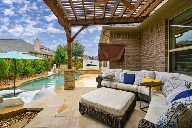 Fenced backyard with outdoor lounge area, a pergola, a pool with connected hot tub, and a patio | Image 28