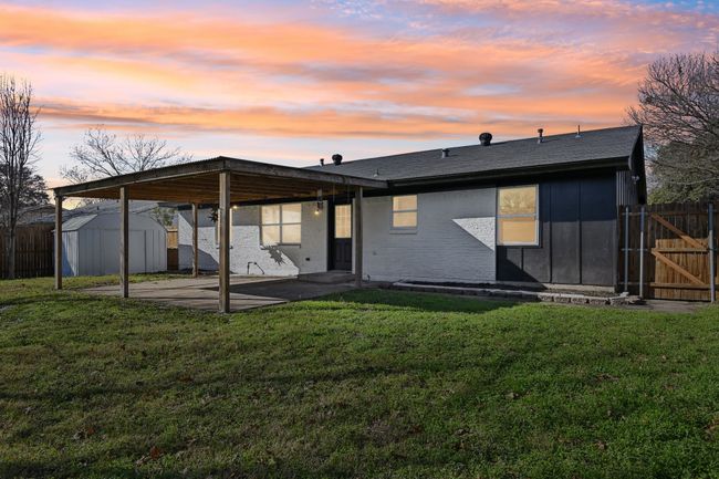 Back of property at dusk featuring a patio area, a gate, board and batten siding, and a carport | Image 29