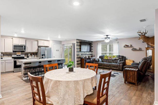 Dining room with light hardwood / wood-style flooring, a healthy amount of sunlight, and ceiling fan | Image 10