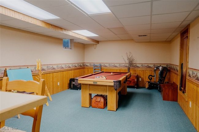 Recreation room featuring carpet, a wainscoted wall, wooden walls, billiards, and a drop ceiling | Image 31