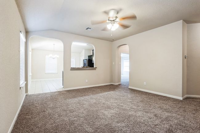 Carpeted spare room with lofted ceiling and ceiling fan with notable chandelier | Image 5