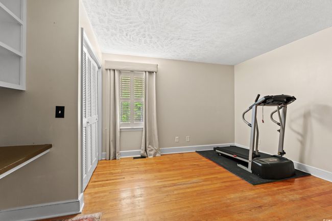 Workout room with baseboards, a textured ceiling, and light wood finished floors | Image 15