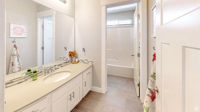 Bathroom with baseboards, shower / washtub combination, and vanity | Image 39