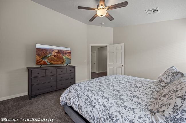 Bedroom featuring dark colored carpet, baseboards, lofted ceiling, and a ceiling fan | Image 38