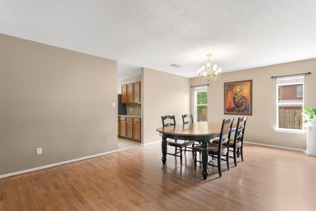 Elegant dining room, chandelier, and wood flooring. | Image 8