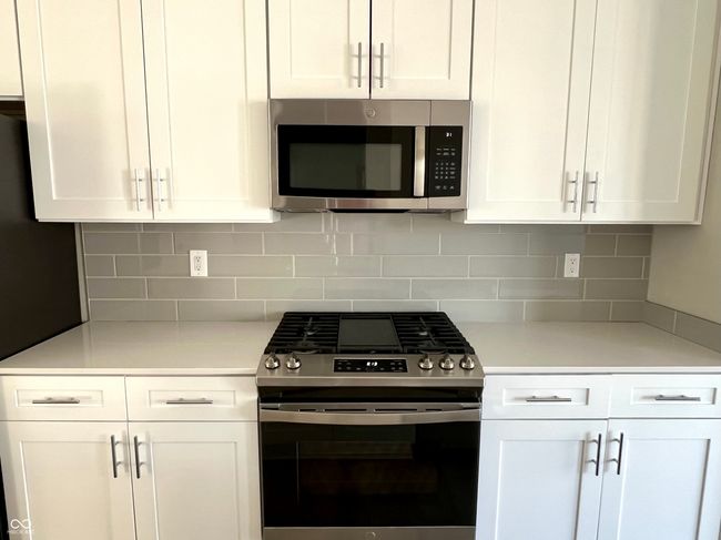 Gourmet chef's kitchen with SS appliances, gas range, Shelf Genie cabinet system, quartz countertops. | Image 17