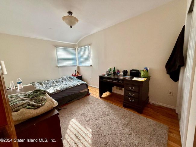 Bedroom featuring hardwood / wood-style flooring and lofted ceiling | Image 7