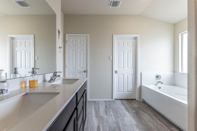 Full bathroom with a sink, visible vents, wood finished floors, and vaulted ceiling | Image 15