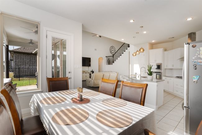 Dining area with stairway, light tile patterned floors, ceiling fan, visible vents, and recessed lighting | Image 17