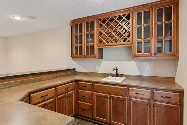The wet bar has an abundance of counterspace, wine storage and a beverage fridge | Image 22