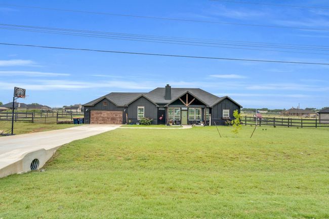 View of front of home featuring driveway, board and batten siding, and an attached garage | Image 4