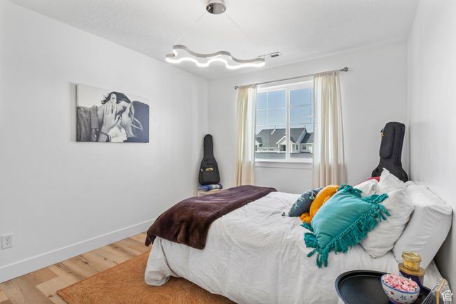 Bedroom featuring visible vents, baseboards, and wood finished floors | Image 20