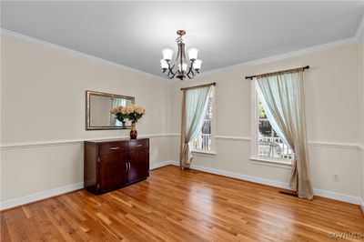 Dining room featuring ornamental molding, an inviting chandelier, and light hardwood / wood-style floors | Image 2