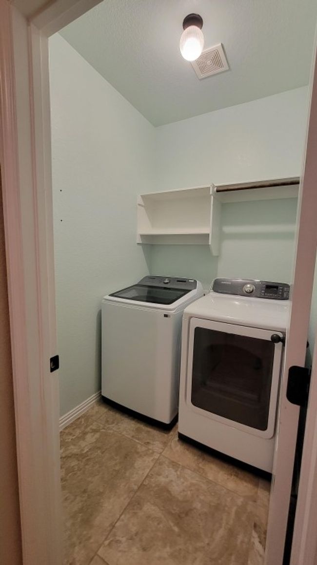 Laundry room featuring washing machine and clothes dryer and baseboards | Image 12