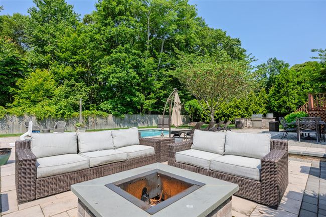 Fenced backyard with an outdoor living space with a fire pit, a patio, and outdoor dining area | Image 39