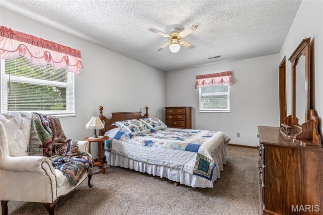 Carpeted bedroom with a textured ceiling and ceiling fan | Image 32