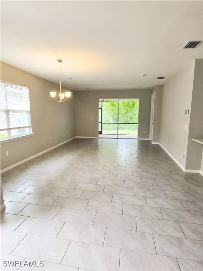 Unfurnished room featuring a chandelier, baseboards, and light tile patterned floors | Image 16