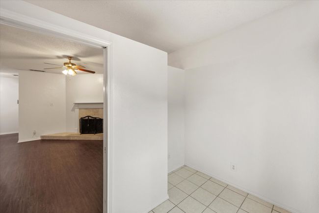 Unfurnished room featuring a ceiling fan and a tiled fireplace | Image 12