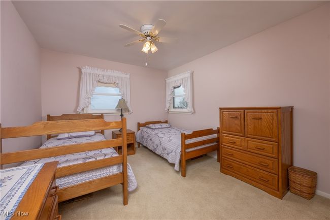 Bedroom featuring ceiling fan and light colored carpet | Image 30