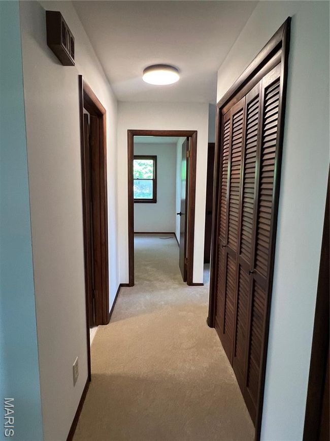 Hall with light carpet and baseboards | Image 11