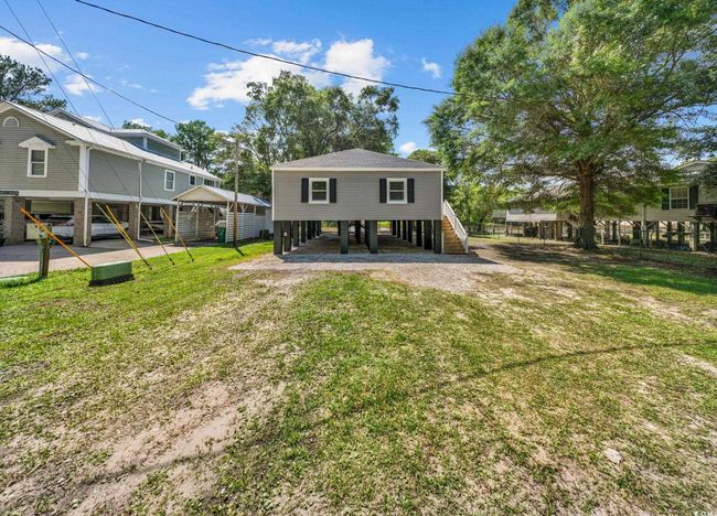 Rear view of property with stairs, a lawn, a carport, and driveway | Image 9