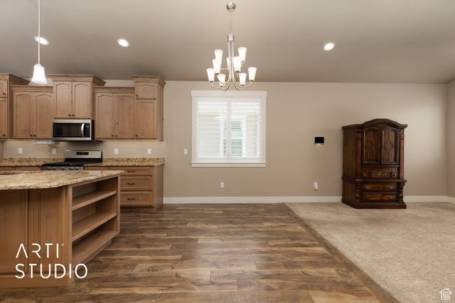 Kitchen featuring stainless steel appliances, a chandelier, open shelves, decorative light fixtures, and recessed lighting | Image 19
