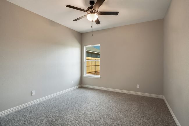 Carpeted empty room with ceiling fan and baseboards | Image 18