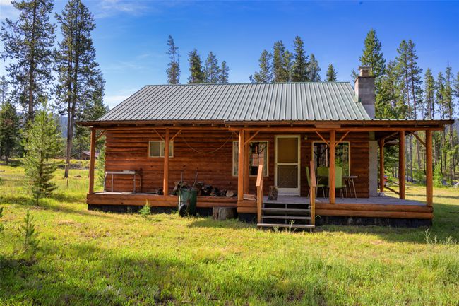 View of front facade featuring a chimney, a metal roof, and a front yard | Image 9