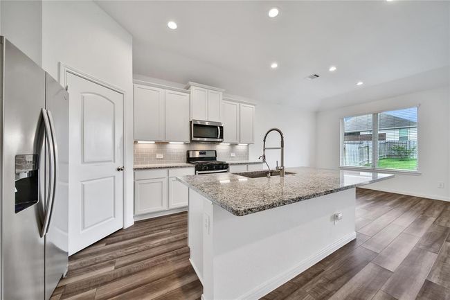 A nice island kitchen with a walk-in pantry awaits. | Image 13