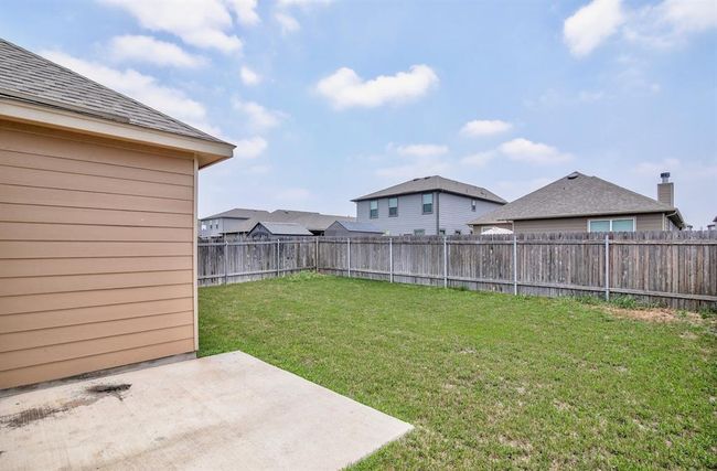 Fenced backyard with a patio | Image 23