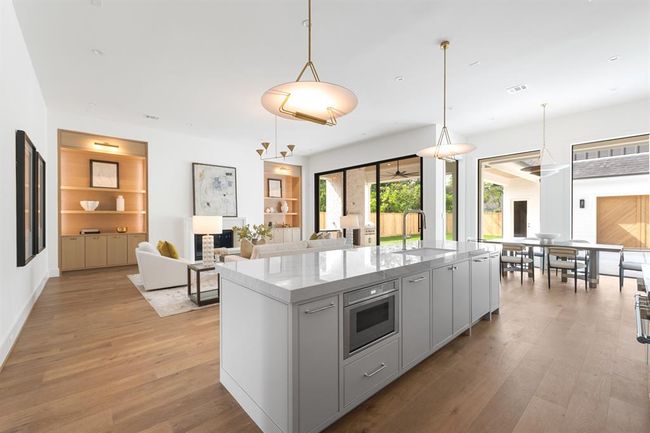 A stunning kitchen bathed in natural light, with large windows allowing sunlight to flood the space. | Image 18