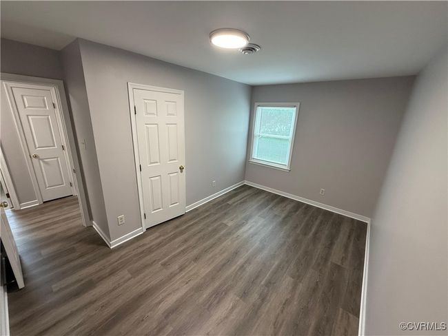 Unfurnished bedroom with dark wood-style floors and baseboards | Image 4