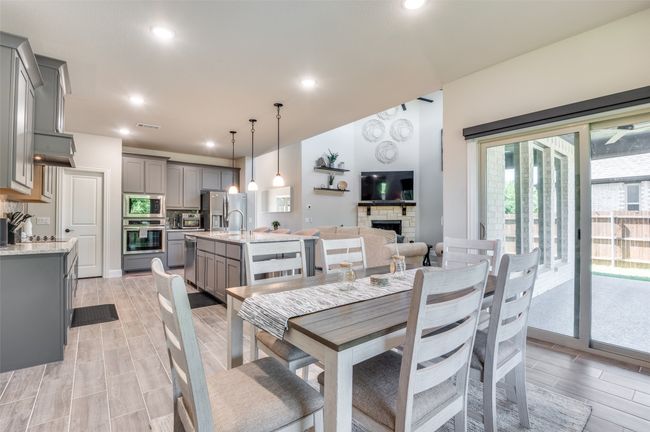 Dining room with wood finish floors, a fireplace, and recessed lighting | Image 11