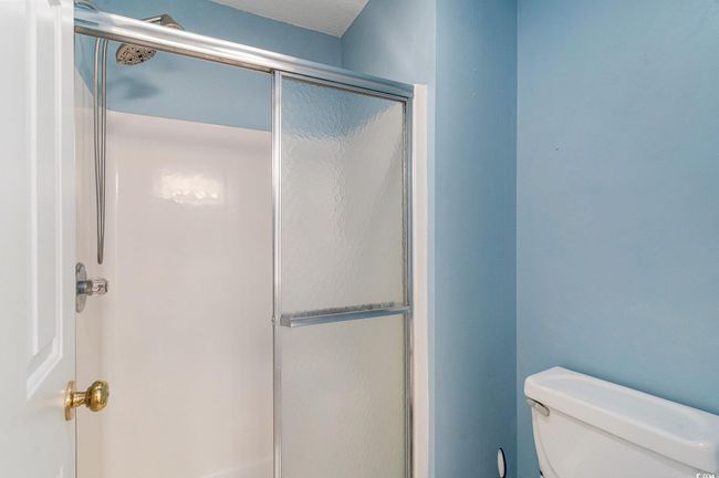 Full bath featuring a shower with door and toilet | Image 6