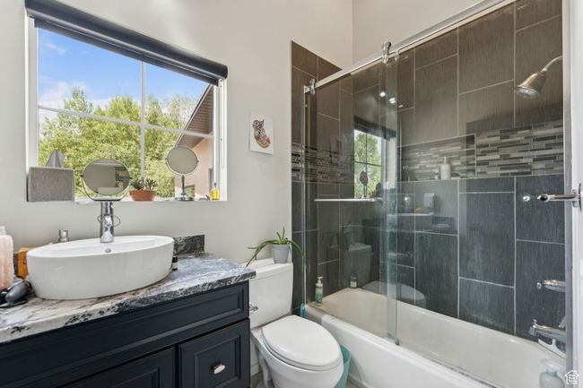 Full bathroom featuring vanity, enclosed tub / shower combo, and toilet | Image 36