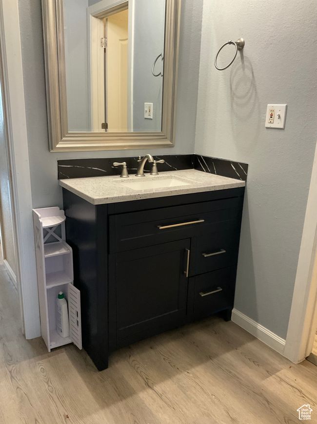 Bathroom with wood finished floors, vanity, and baseboards | Image 16