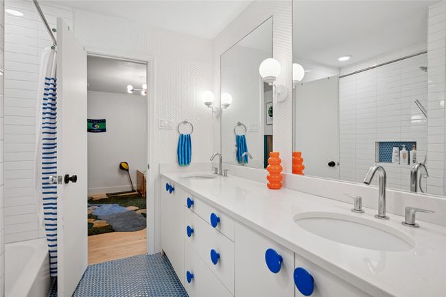 Blue accented jack and jill bathroom with intricate penny tile floor and wall tile. | Image 17