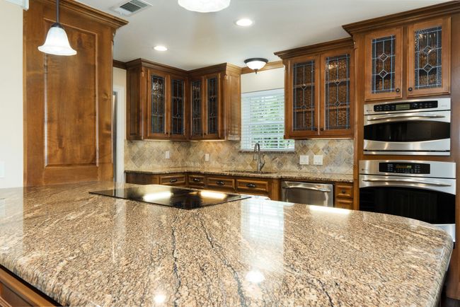 Kitchen featuring appliances with stainless steel finishes, decorative backsplash, glass insert cabinets, recessed lighting, and decorative light fixtures | Image 14