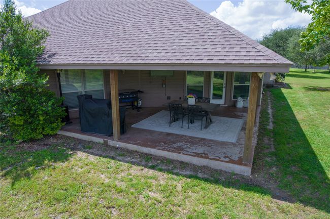Rear view of house featuring a lawn, roof with shingles, and a patio | Image 32
