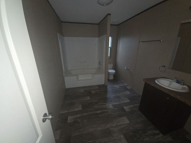 Bathroom with toilet, vanity, and shower combination | Image 10