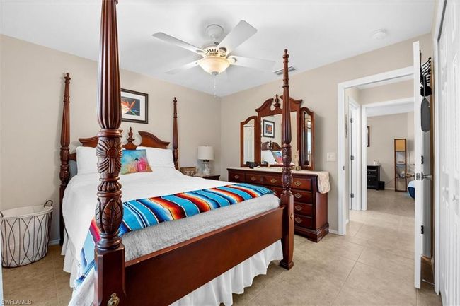 Bedroom with light tile patterned floors, visible vents, and ceiling fan | Image 10