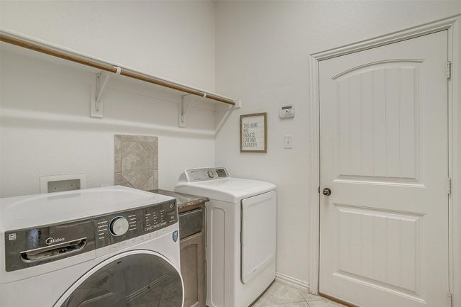 Laundry room featuring washing machine and dryer and light tile patterned flooring | Image 31