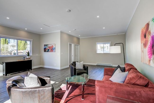 Living area featuring a baseboard radiator, plenty of natural light, wood finished floors, recessed lighting, and crown molding | Image 21