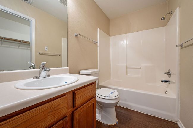 Full bath with toilet, wood finished floors, shower / washtub combination, and vanity | Image 19